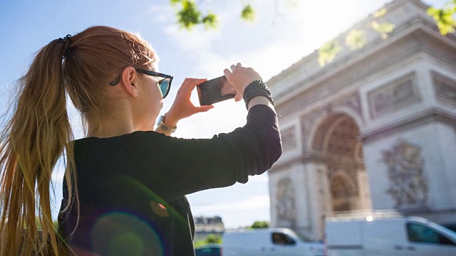 游客走在巴黎街头，拍摄凯旋门的照片视频素材