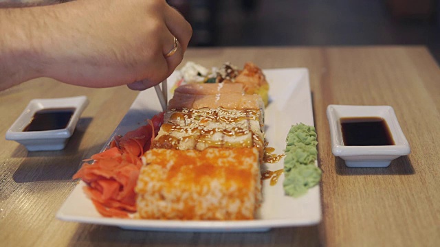 男人在餐厅用筷子吃寿司视频素材