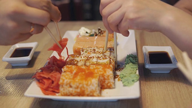 人们在日本餐馆或寿司店吃面包卷视频素材