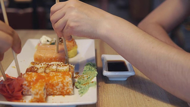 朋友们吃寿司，蘸酱吃视频素材