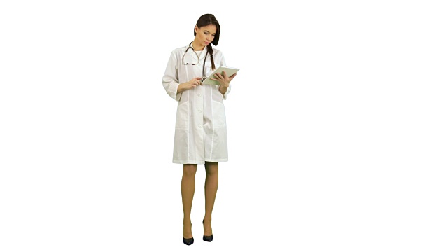 漂亮的女医生与听诊器使用数字平板在白色的背景视频下载