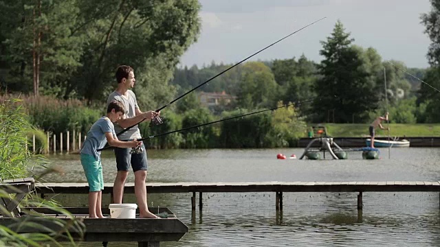 父子在湖边钓鱼视频素材