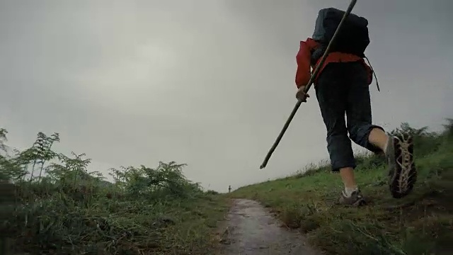 朝圣者的女人走过卡米诺，在雨季受欢迎的徒步路线视频素材