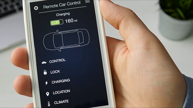 男子检查他的汽车充电水平。使用智能手机应用虚拟接口远程控制汽车充电。视频下载