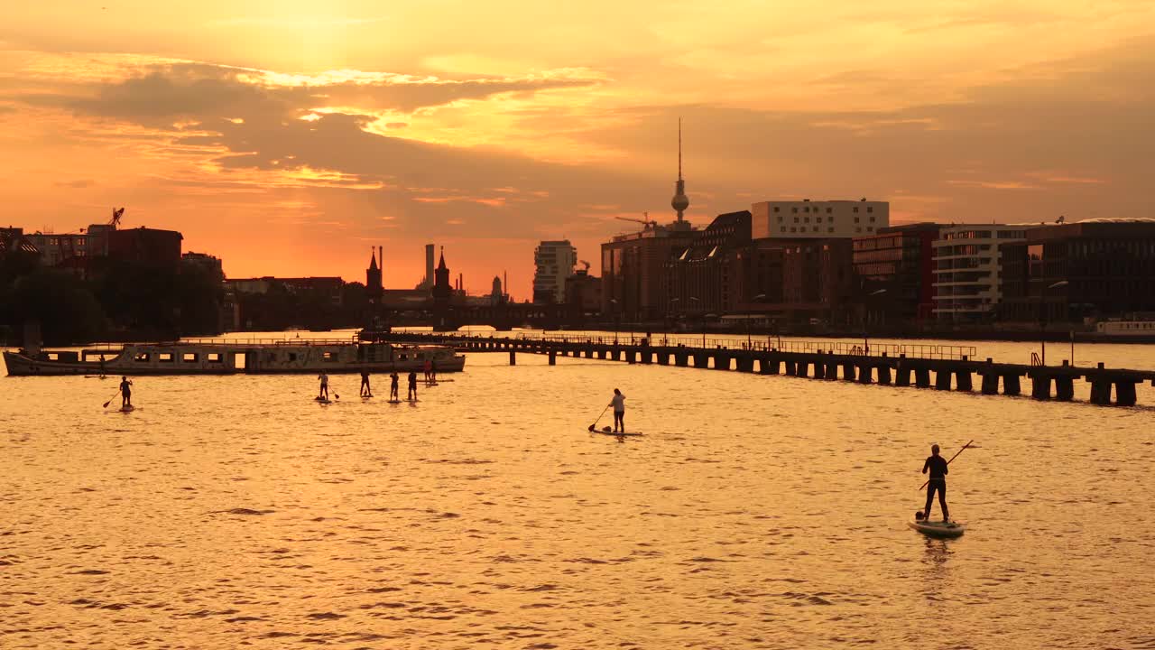 柏林夏日日落天际线与划桨冲浪的人视频下载