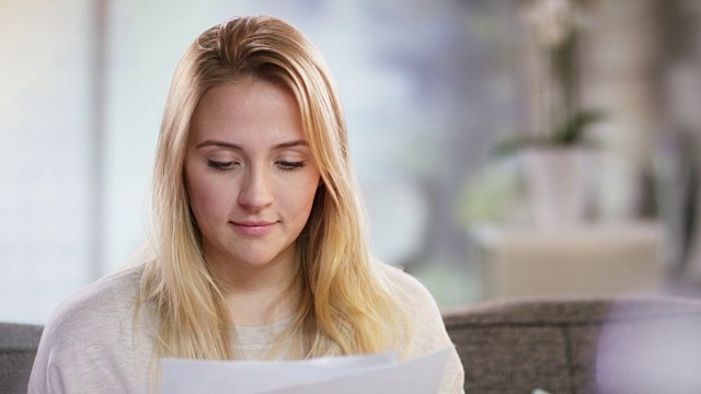 一个微笑的年轻女子读一封信的肖像视频素材