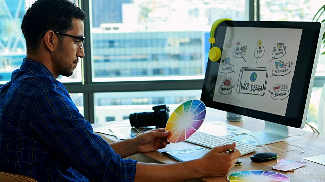 男性平面设计师在他的办公桌上用平板电脑工作视频素材