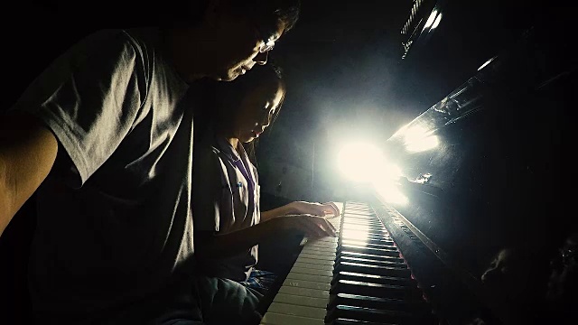 亚洲小女孩和她的父亲弹钢琴视频素材