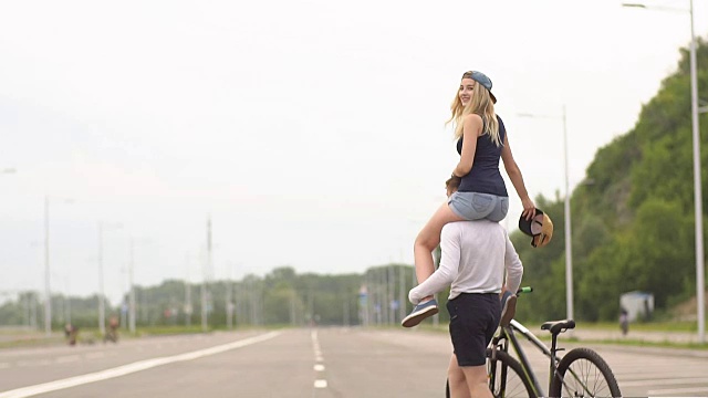 快乐的年轻夫妇笑着骑自行车，慢动作视频下载