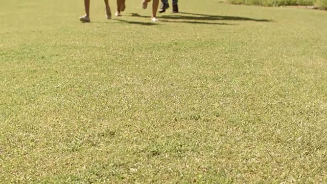 倾斜拍摄的家庭在公园跑向相机视频素材