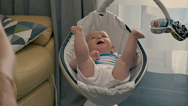 婴儿躺在摇篮里时，母亲在家工作视频素材