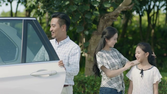 亚裔父亲抱着儿子下车，母亲和女儿在旁边视频素材