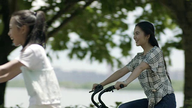 亚洲母亲和女儿骑在湖边散步在夏天视频下载