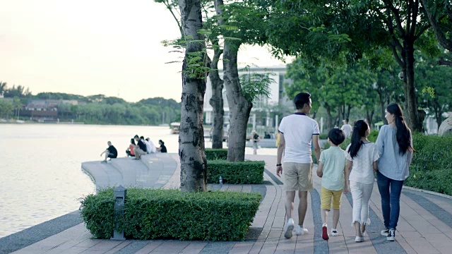 黄昏时分，亚洲一家四口在海滨散步视频素材