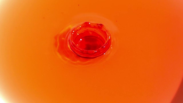 慢莫红色滴在橙汁里视频素材