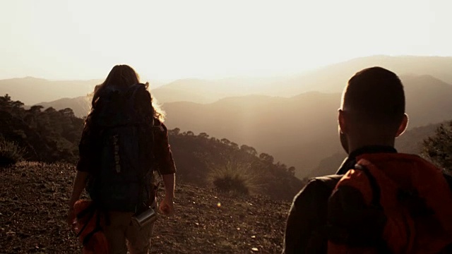 成功的女性和男性徒步旅行者到达了风景优美的山边视频素材