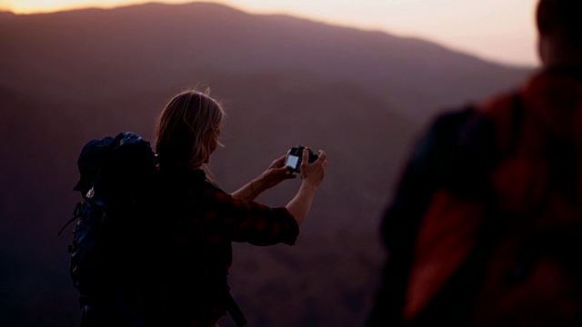 高级女徒步者在山顶拍摄全景照片视频素材