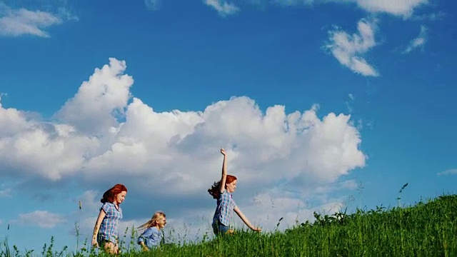 无忧无虑的孩子们拿着风筝沿着绿色的小山奔跑视频素材