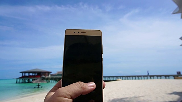 一个智能手机在游客手中拍照的POV镜头。享受海洋假期视频下载