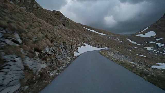 秋天的午后，汽车沿着岩石和密实的积雪快速行驶在乡间小路上视频下载