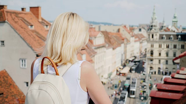 一位年轻的女游客正在高处欣赏这座古老的欧洲城市。奥地利格拉茨。在欧洲旅游。替身拍摄视频素材