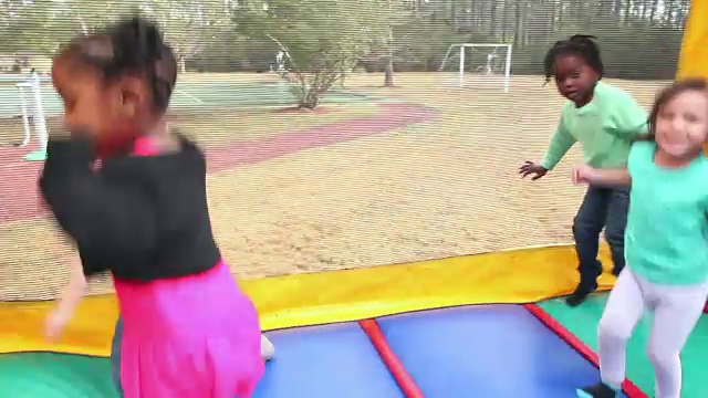 小男孩和小女孩在蹦蹦跳跳的城堡里跳视频素材