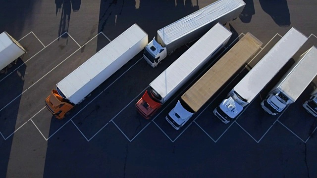 空中鸟瞰图的白色半挂车与其他车辆在特殊停车场。视频素材