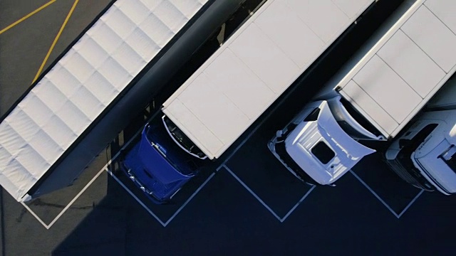 带货物/冰箱拖架的半挂卡车停在专用停车位上的空中俯视图。视频素材
