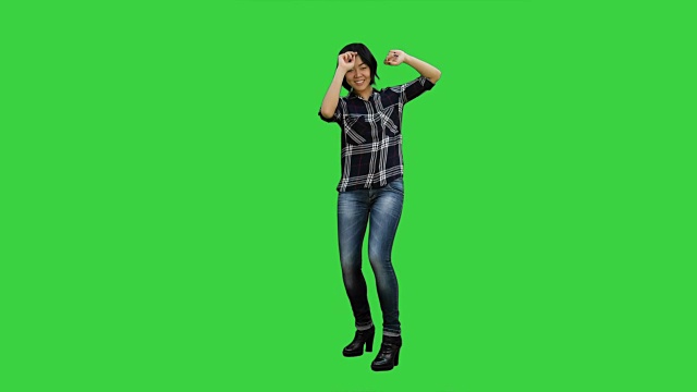 快乐的女孩跳舞和听音乐的绿色屏幕，色度键视频素材