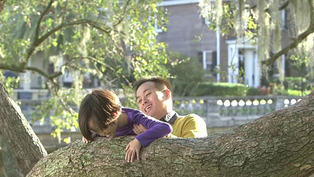 亚洲父亲帮助小女孩爬树视频素材