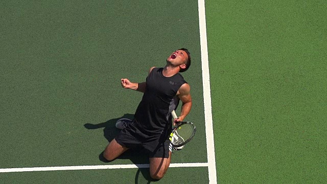 一个网球运动员发球，庆祝得了王牌和成为第一名。视频素材