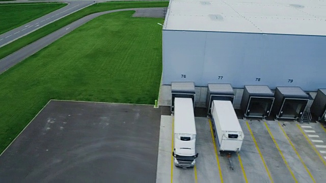 移动空中拍摄的工业仓库装载码头，许多卡车和半挂车装载/卸载商品。视频素材