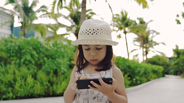 小女孩在玩智能手机视频下载