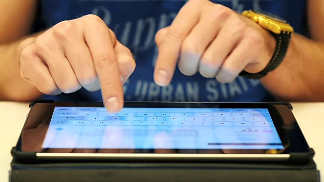男性在平板触摸屏电脑上打字的手的特写视频素材