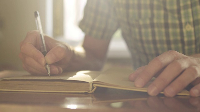 男性用钢笔在笔记本上写字视频素材