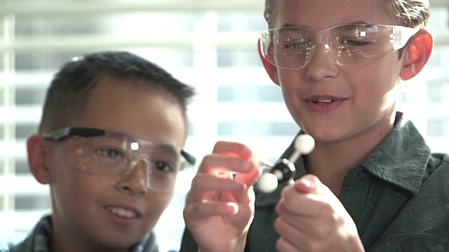 化学课上两个男生用分子模型视频素材
