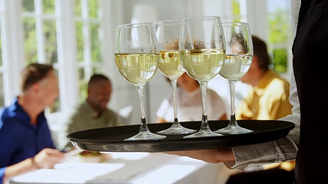 女服务员用托盘端着几杯葡萄酒视频素材