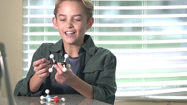 男孩在科学课上谈论分子模型视频素材