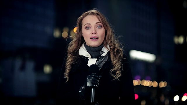 俄罗斯女记者晚上在市中心进行现场报道视频素材