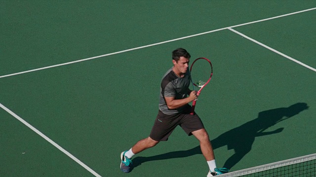 网球运动员跑过球场去投中制胜一球。视频素材