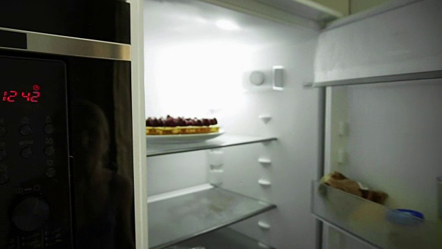 近距离观察女人的手来到冰箱，打开门，拿出盘子与蛋糕装饰树莓。自制的蛋糕。方准备视频下载