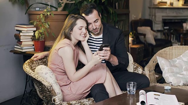 一对夫妇在舒适的公寓里玩智能手机视频素材