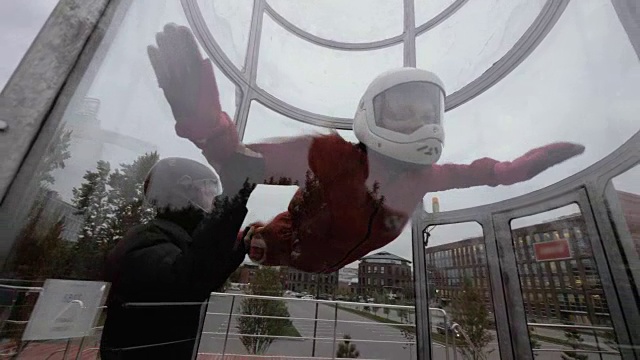 教练在风洞里教女人跳伞。在风洞里飞行的女人视频下载
