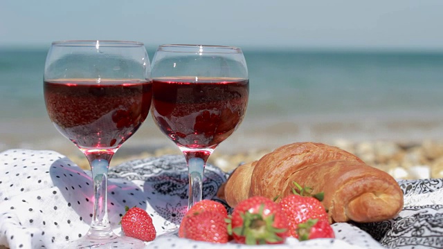 两杯红酒，水果和羊角面包，还能看到美丽的海景视频素材