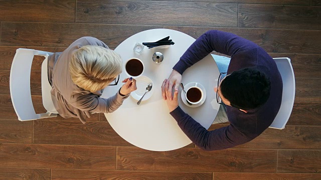 快乐的年轻夫妇在咖啡店喝咖啡聊天视频素材