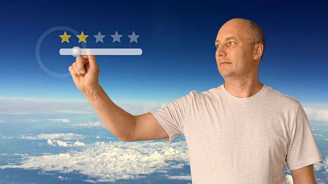 在虚拟屏幕上得到5颗星。男子在虚拟屏幕上移动手指。在一个晴朗的日子里，蓝天和白云。白人表示满意。视频素材