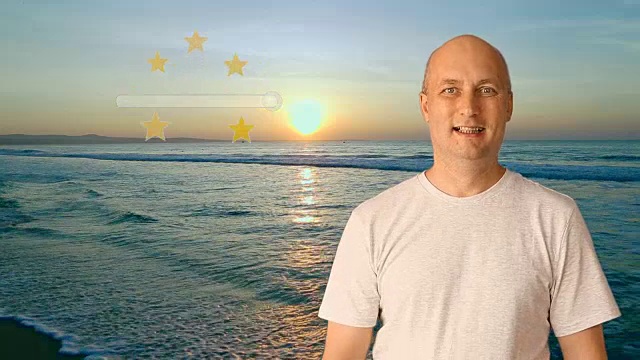日落时分，一位成年男子站在海边的海滩上，显示出该度假村极好的评级。这片海滩有很高的五星分数，因为它又长又漂亮。视频素材