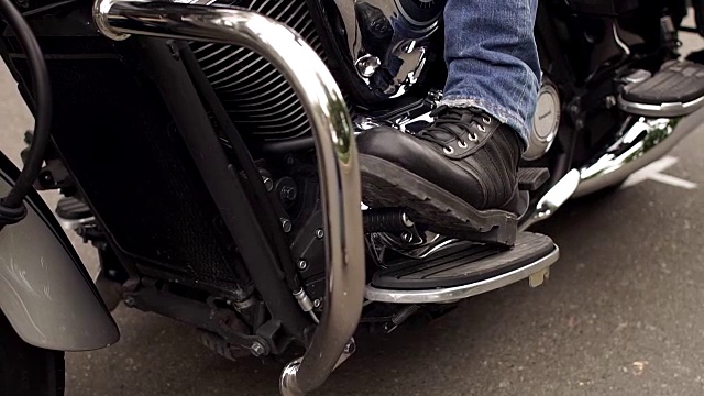 在摩托车上穿着靴子的脚夫的特写。视频素材
