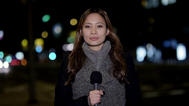 亚洲女新闻记者在市中心进行现场报道视频下载