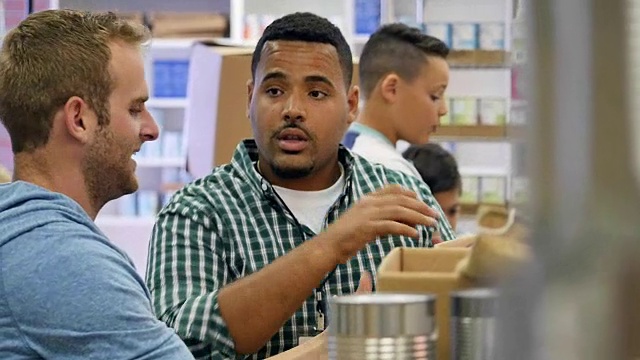 不同的年轻人在食品银行做志愿者时互相交谈视频素材